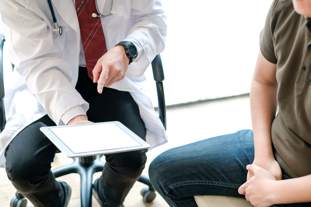 Doctor holding clipboard talking to patient.