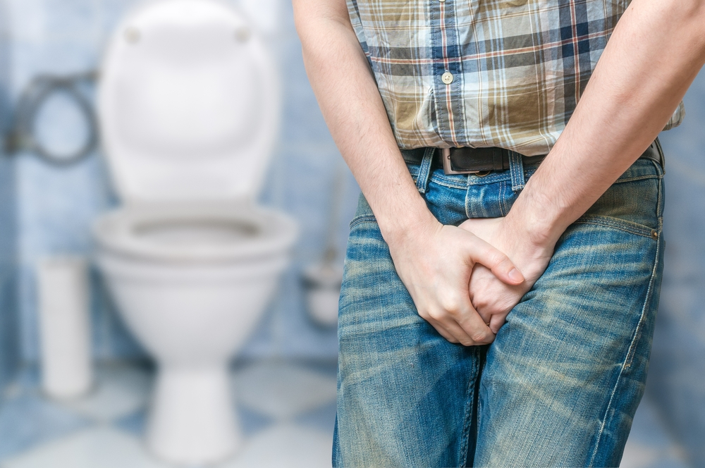 man struggling to hold urine in